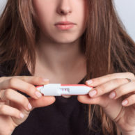 patient looking at positive pregnancy test